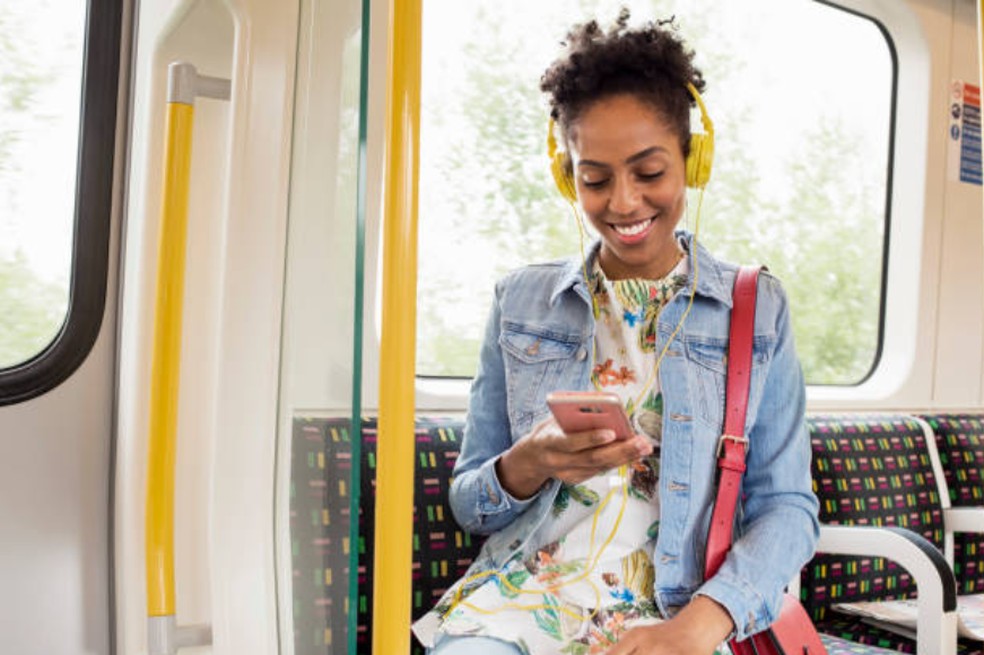 Mãe escutando podcast no transporte público — Foto: Getty Images