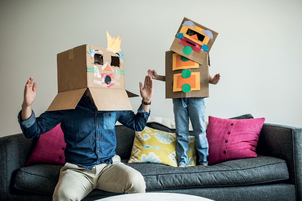Pai e filho com fantasias feitas de caixa — Foto: Getty Images
