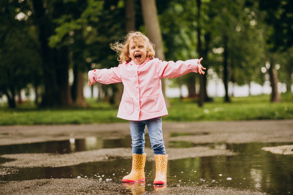 Menina brincando na chuva — Foto: Freepik