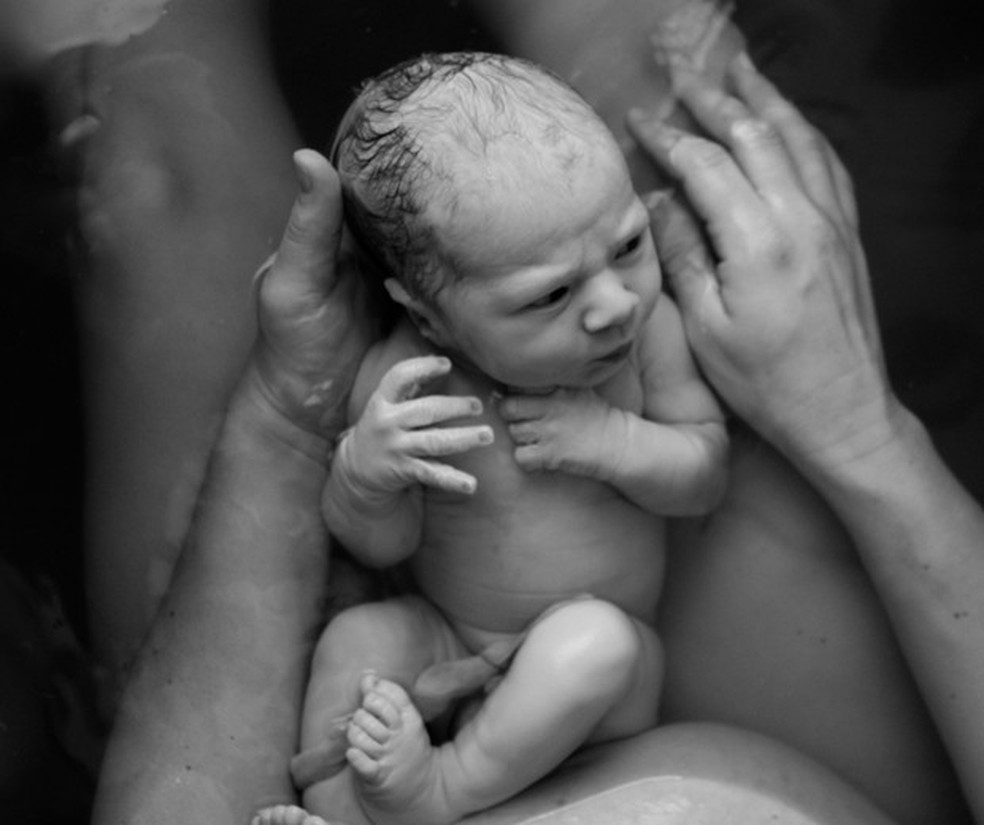 Recém-nascido no colo da mãe depois de parto na água  — Foto: Getty Images