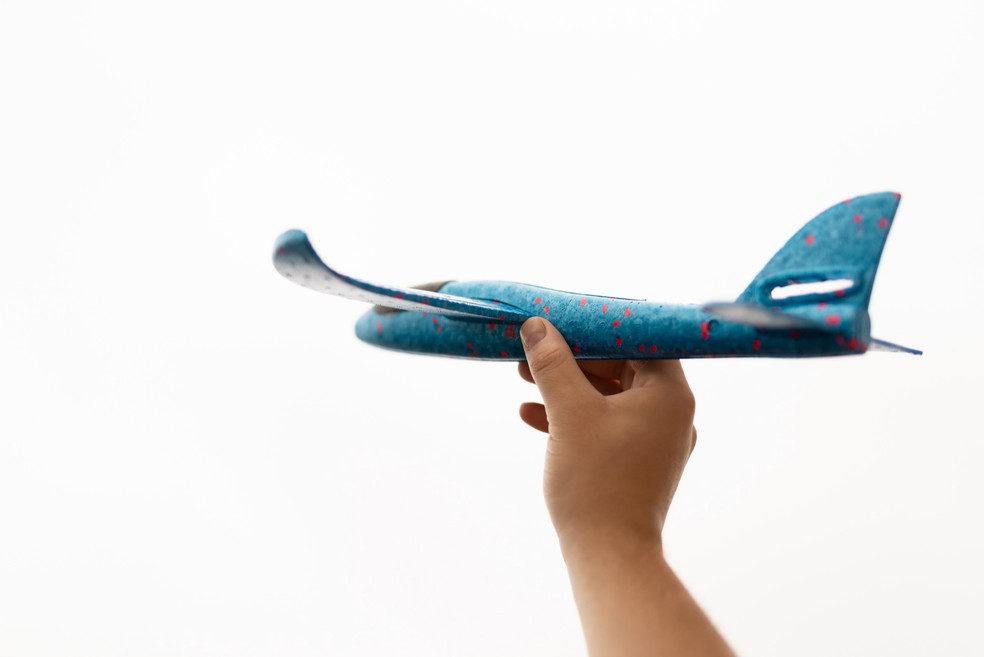 Criança segurando avião de brinquedo — Foto: Freepik
