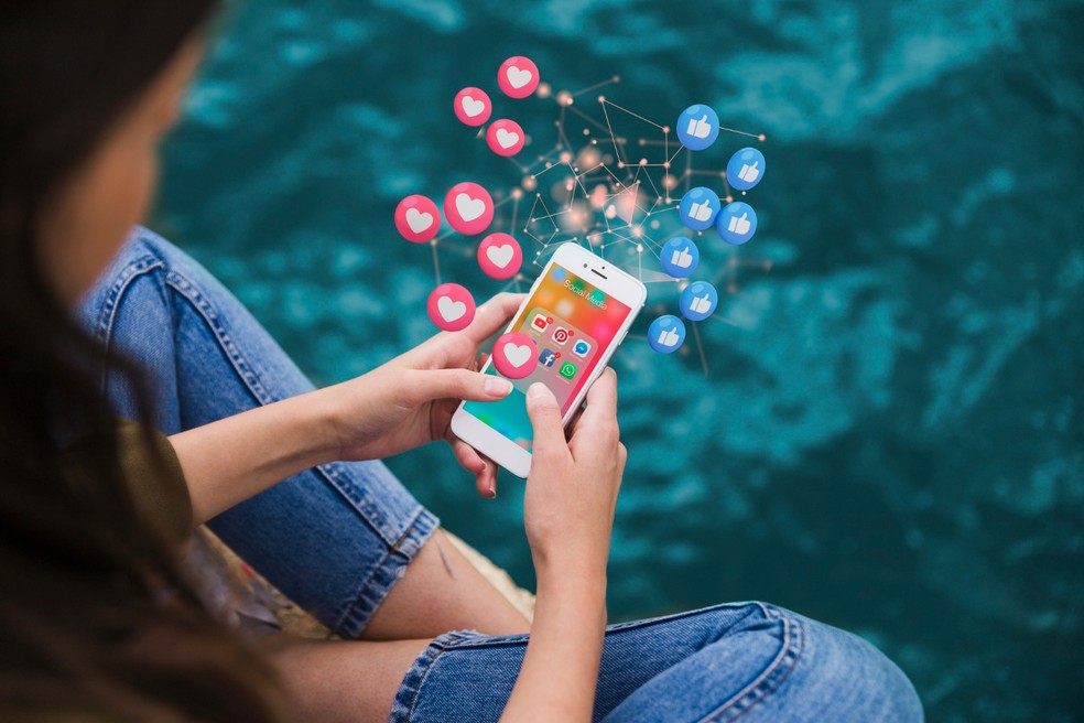 Menina usando as redes sociais no celular — Foto: Freepik
