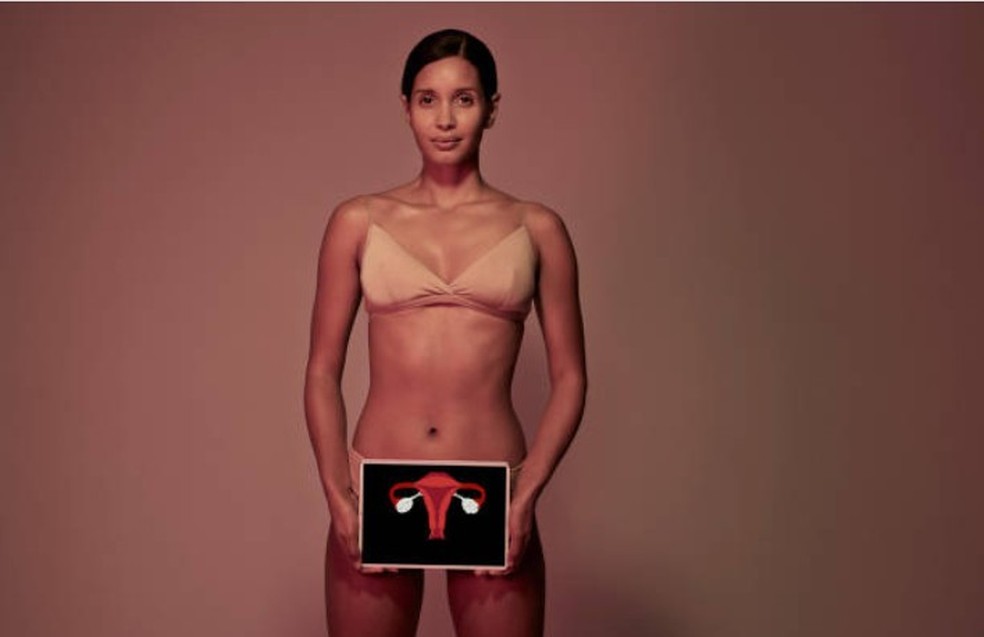 Mulher segura representação do sistema reprodutor feminino, incluindo canal vaginal, útero, trompas de Falópio e ovário (Foto: Getty Images) — Foto: Crescer