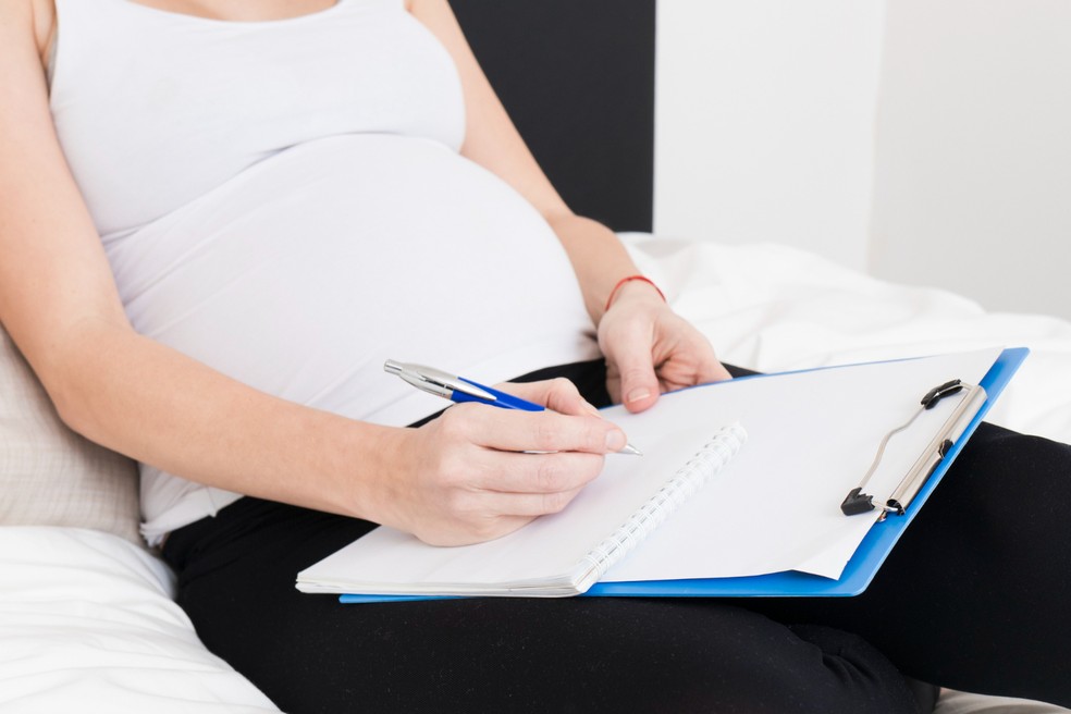 Mulher grávida escrevendo plano de parto — Foto: Freepik