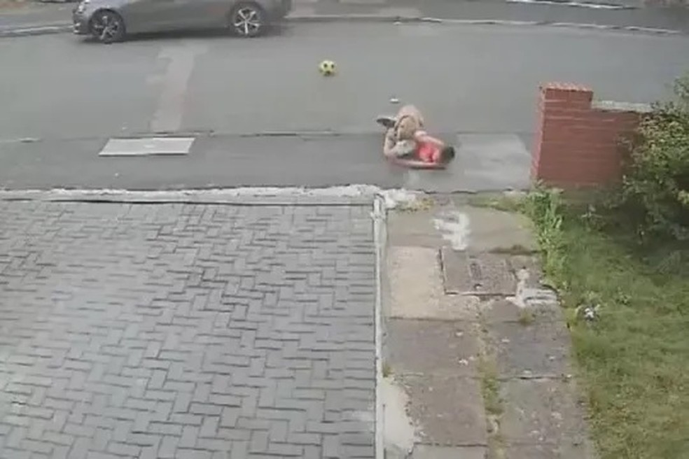 Menino é atacada por cão enquanto jogava futebol na rua — Foto: Reprodução/Mirror