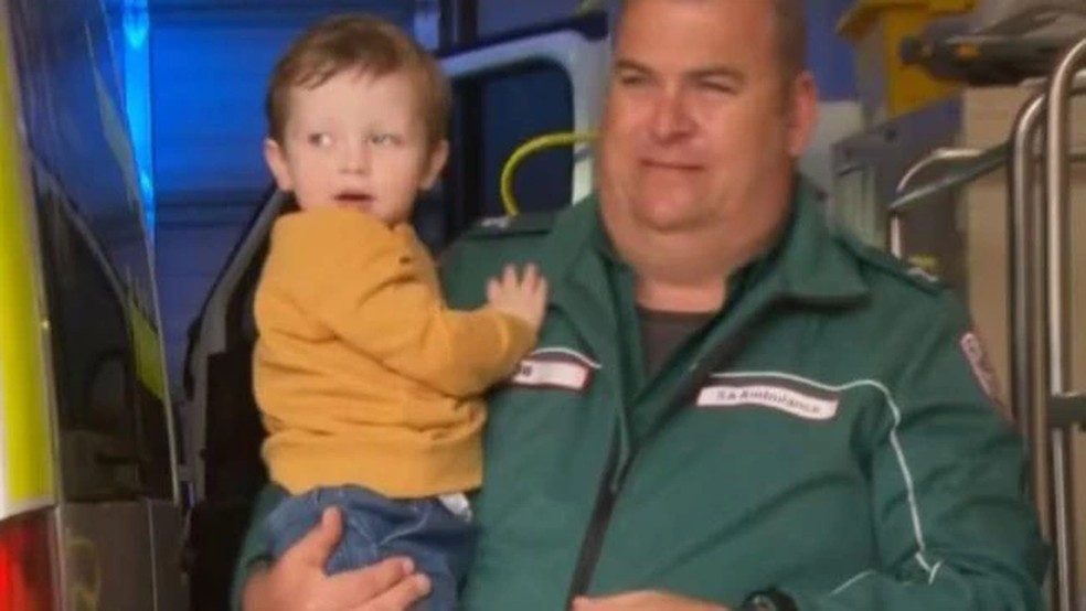 O paramédico voluntário Robert Davis salvou a vida de Grayson Garrad após um incidente em que a churrasqueira caiu sobre ele. — Foto: Reprodução Kidspot